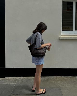 @francescasaffari wearing a brown woven bag with shorts and a t-shirt