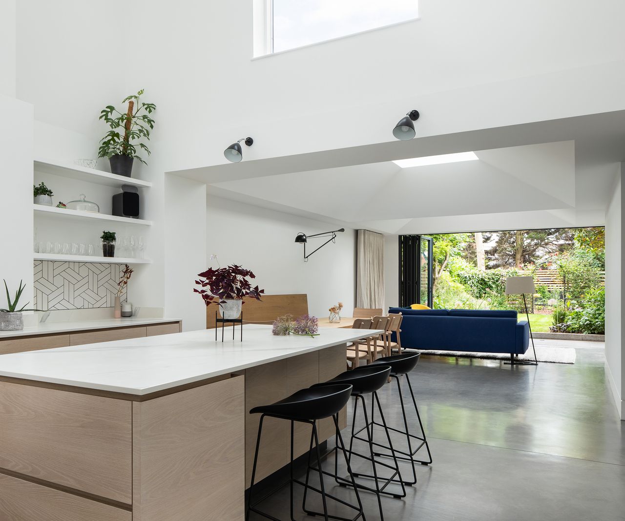 A contemporary ground floor kitchen extension with clerestory window above and fully open bifold doors to the rear