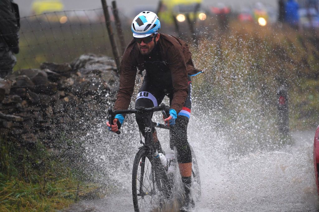 Luxembourg's Ben Gastauer grits his teeth and goes for it through one of the race's many huge puddles