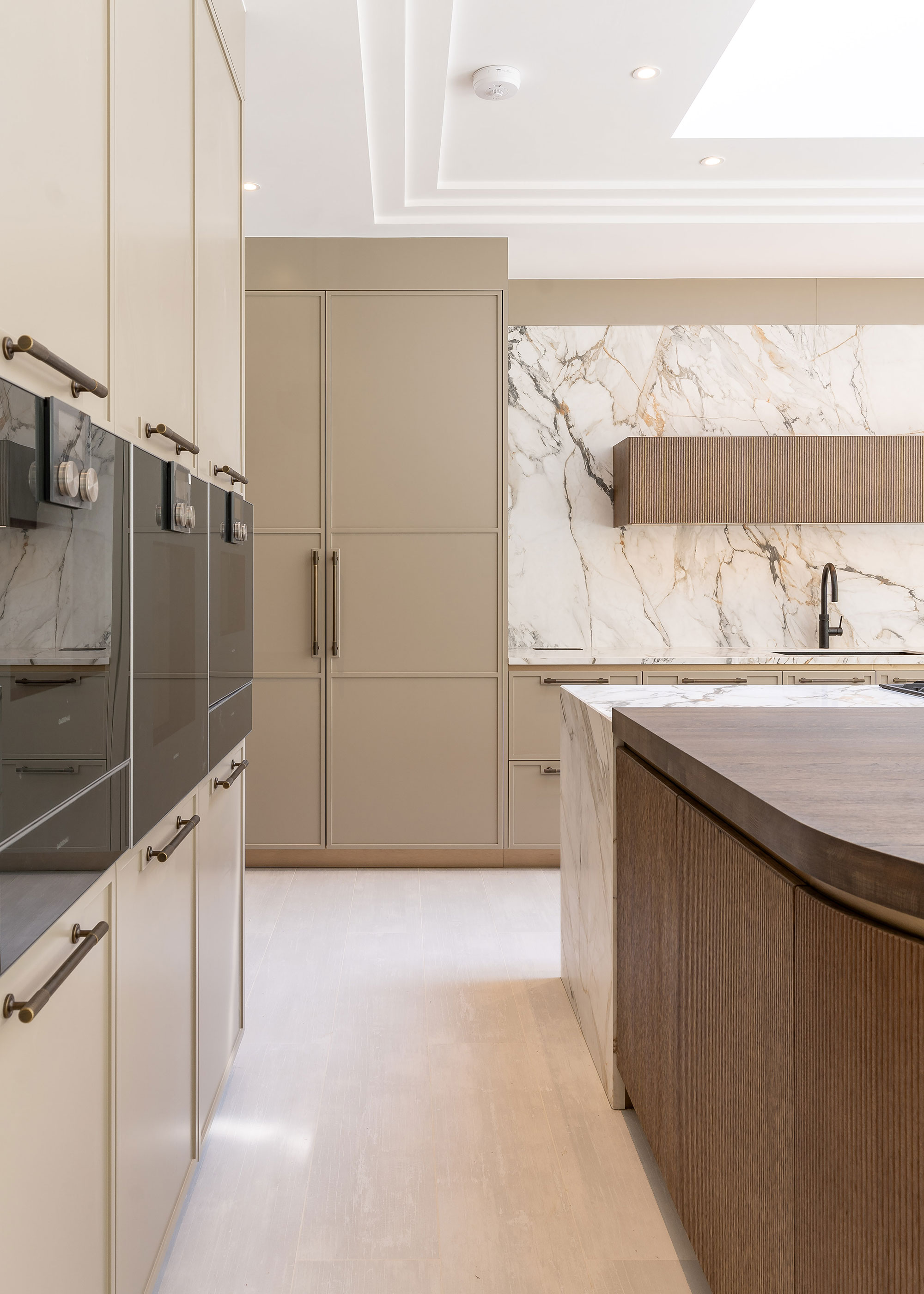 beige modern kitchen with built-in eye level ovens
