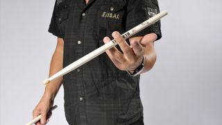 Man holds a pair of drumsticks