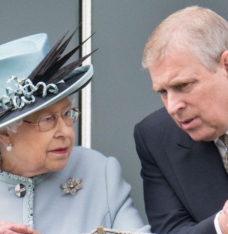 Queen Elizabeth in a blue coat and hat leaning forward and talking to Andrew Mountbatten-Windsor at the Epsom Derby