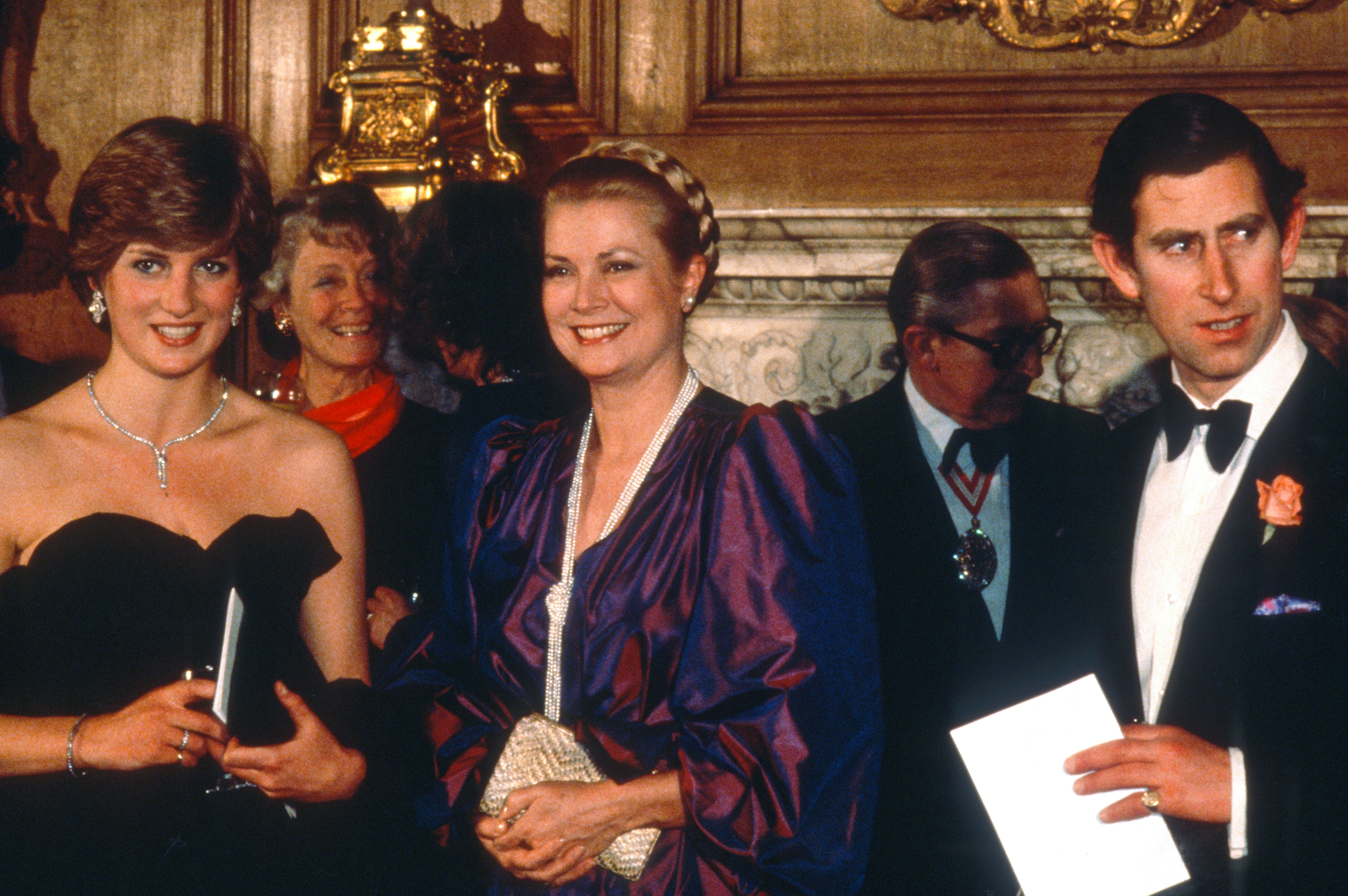 Princess Diana wears a strapless black taffeta Emanuel dress and poses next to Princess Grace Kelly of Monaco and King Charles on March 9, 1981 in London, United Kingdom