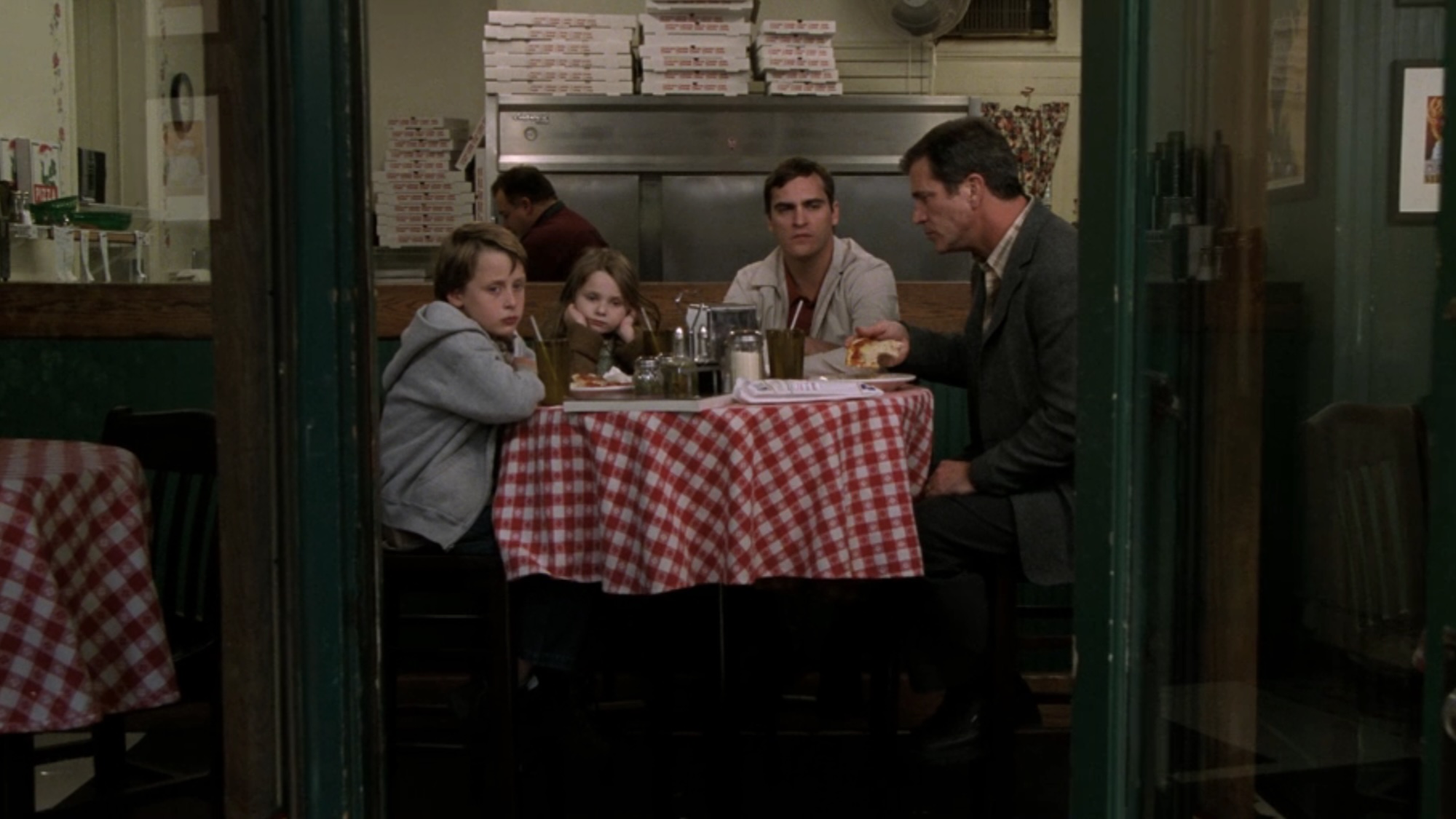 Looking through a doorway at the family sitting together in a restaurant.