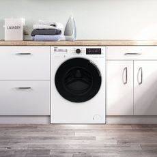 White Beko washer dryer under a wooden counter with white doors