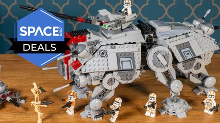 A Lego Star Wars AT-TE Walker on a desk, with minifigures of Clone Troopers and battledroids. 