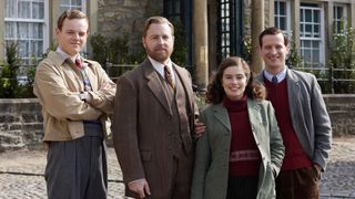 Callum Woodhouse as vet Tristan in a beige jacket and colourful jumper, Samuel West as head vet Siegfried in a dark tweed suit, Rachel Shenton as Helen in a green jacket and red jumper and Nicholas Ralph as James in a grey jacket and red jumper stand outside the veterinary practice in All Creatures Great and Small.