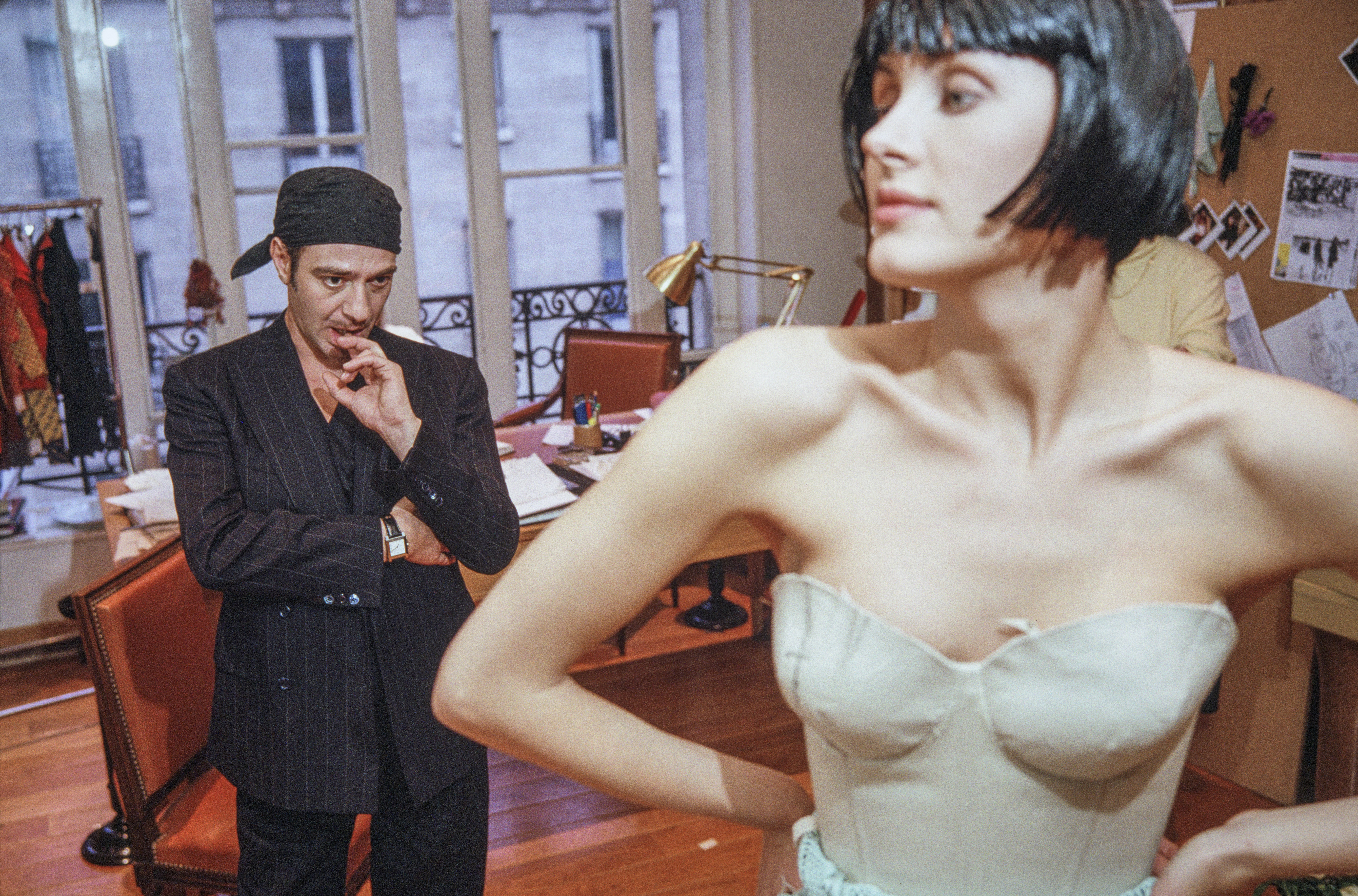 Fashion designer John Galliano reviews a model during a fitting at Christian Dior's Paris atelier before a couture runway show.