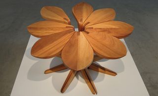 View of the 'Love Me, Love Me Not' table by John Vogel and Justin Plunkett - a wooden table shaped like a flower made up of individual petal-shaped tables that can be used separately