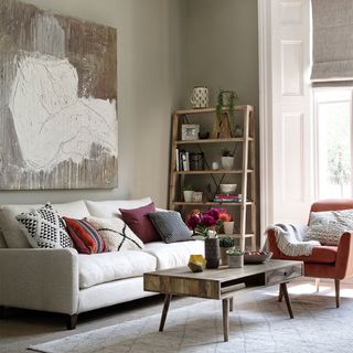 neutral living room with cream sofa and oversized artwork on wall