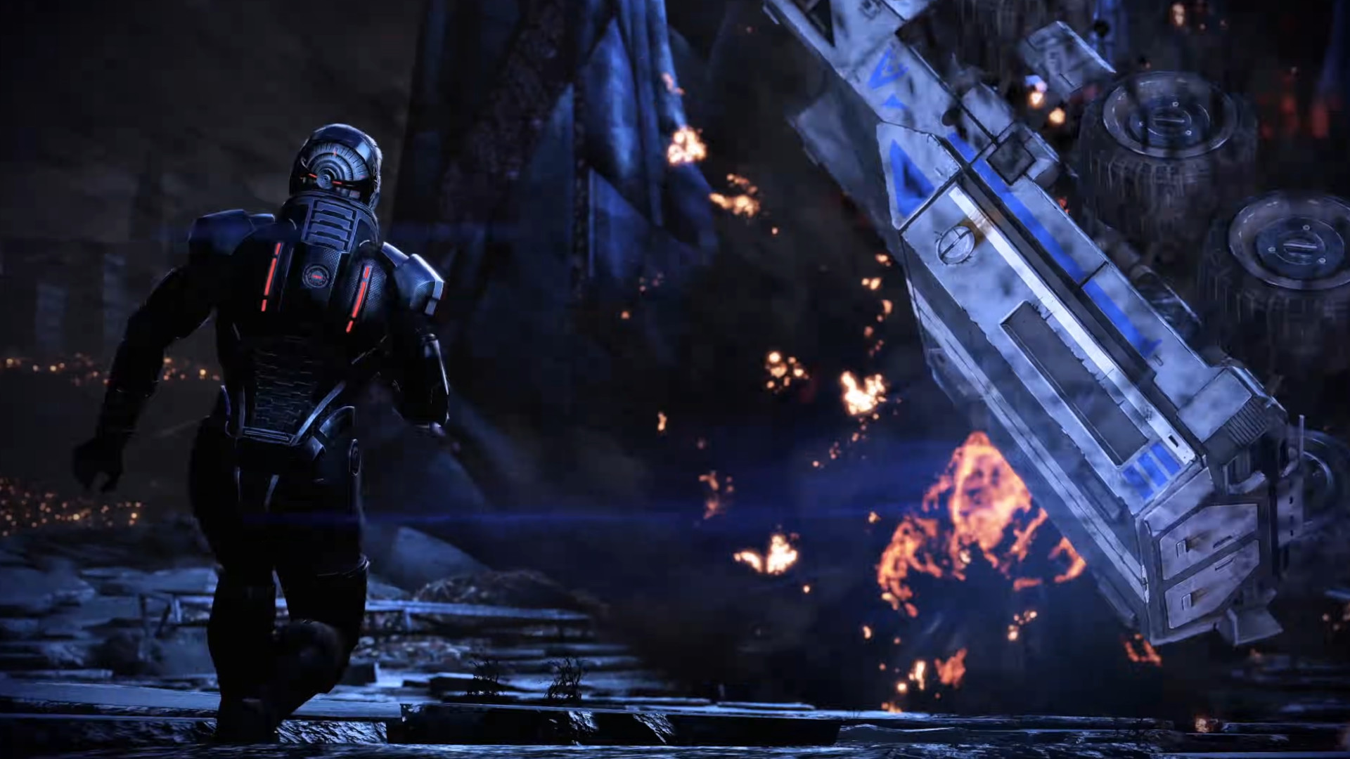 Commander Shepard running towards a burning vehicle during the trailer for the RPG Mass Effect Legendary Edition.