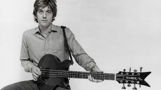 Portrait of musician Nick Lowe playing a Hamer guitar, circa 1990. 