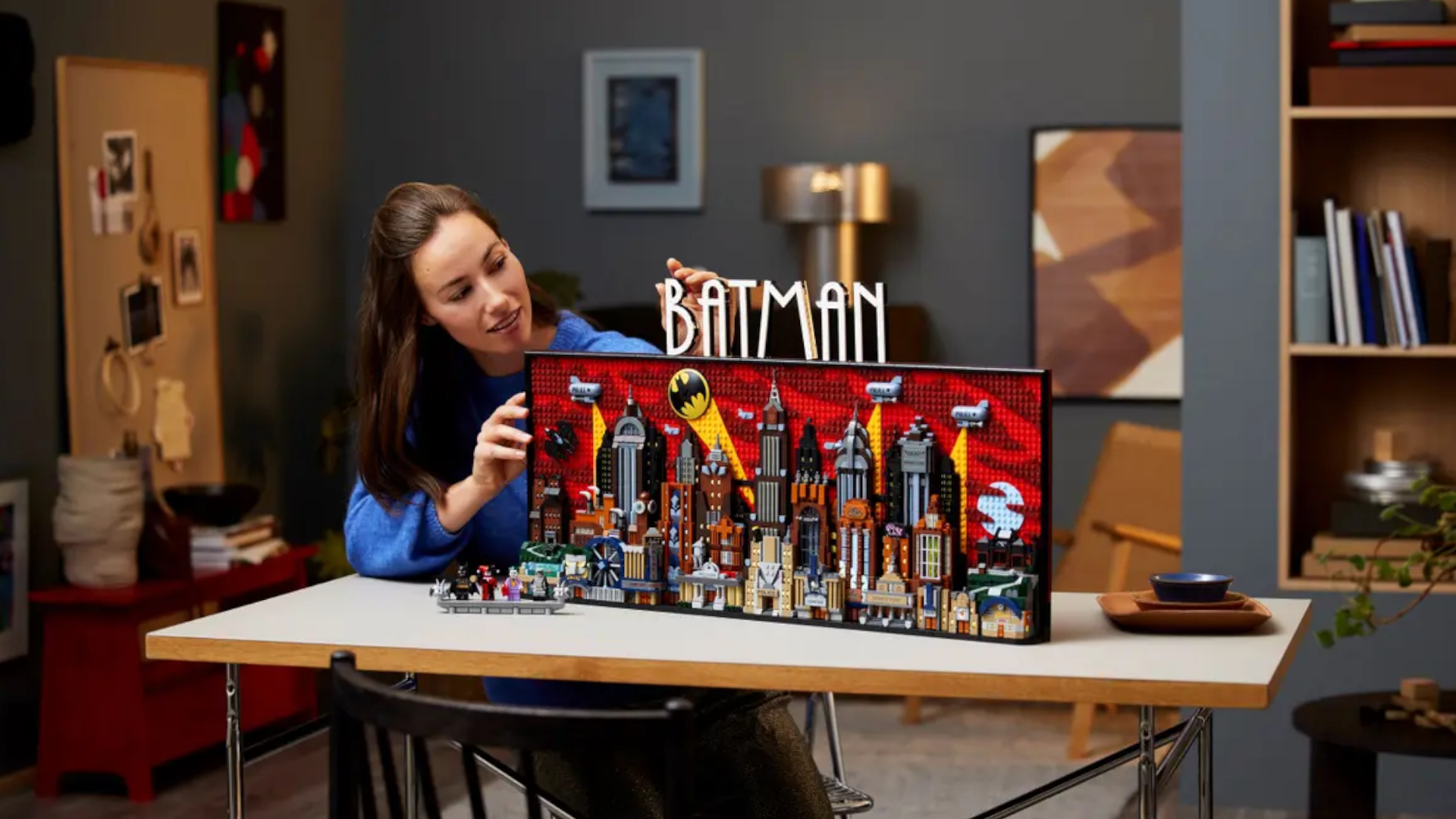 A woman looks at Lego Batman: The Animated Series Gotham City as it sits on a table