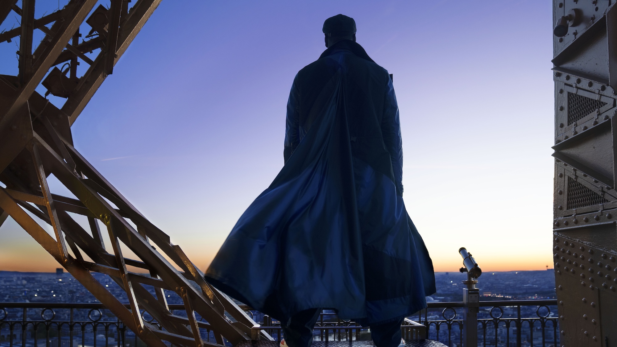 Lupin standing on Eiffel Tower looking out over Paris in Lupin Season 4