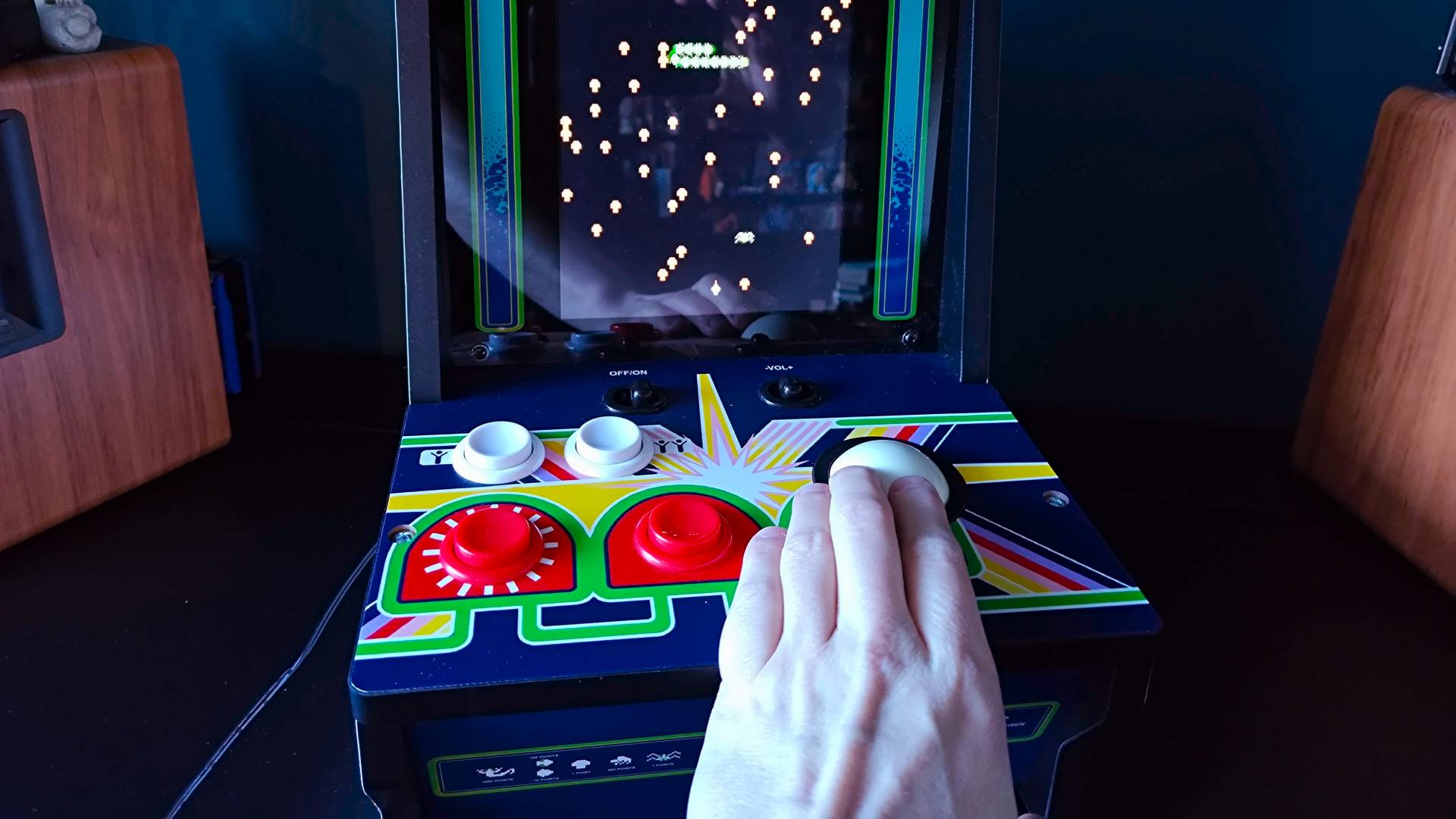 Hand using trackball to play Centipede on Arcade Classics machine.