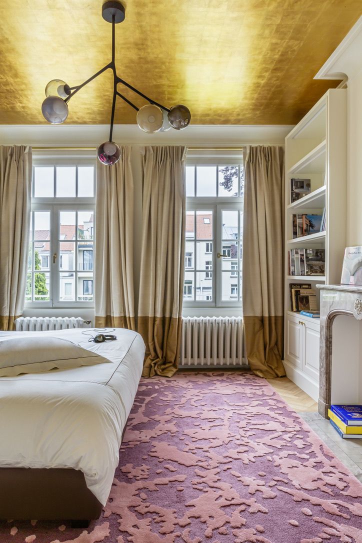 A bedroom with gold leaf on the ceiling