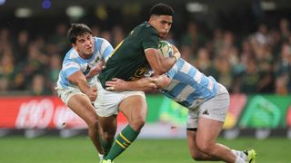 South Africa's fly-half Sacha Feinberg-Mngomezulu (C) evades a tackle from Argentina's prop Joel Sclavi (L) and Argentina's hooker Julian Montoya (R) to score a try