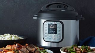 An instant pot next to a plate of food