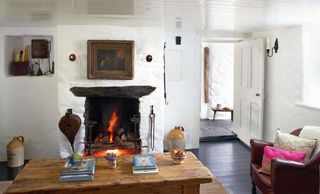 Living room in a humble cottage with open fireplace