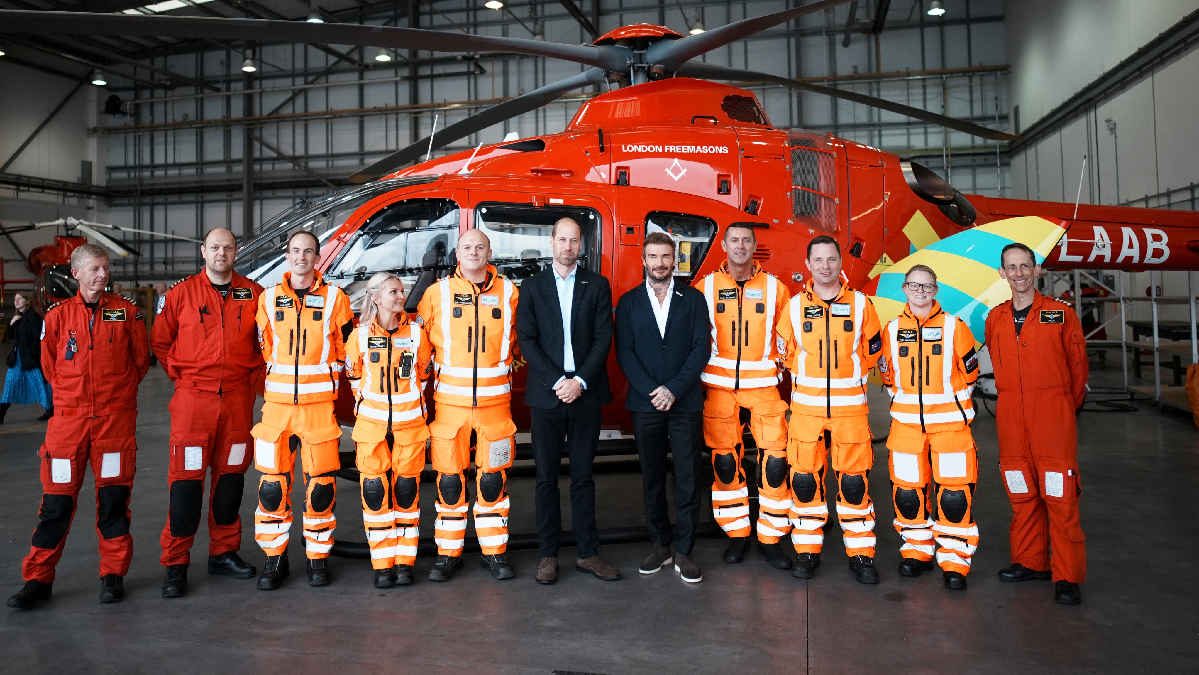 Prince William, Prince of Wales (C-L) and David Beckham (C-R) pose for a photograph with members of the Air Ambulance crew during a visit to RAF Northolt