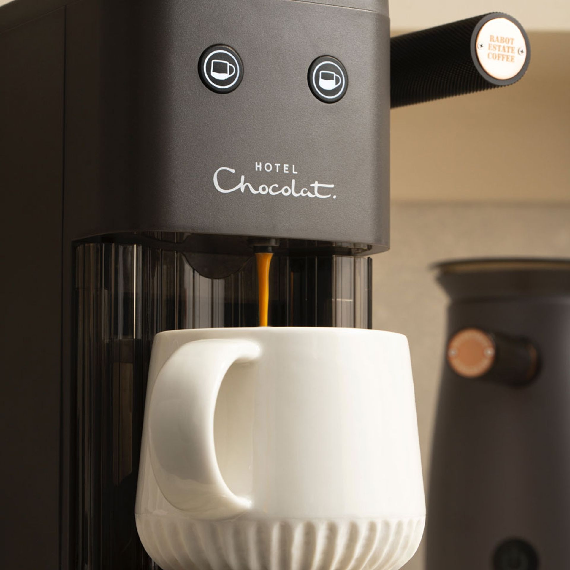 Image of Hotel Chocolat Podster pouring coffee into white mug