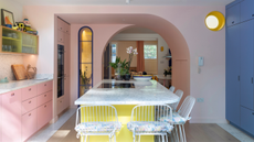 blue, pink, and yellow tri-color kitchen with a half curved arch entryway