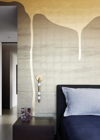 A bedroom with a wood side table and bedside wall-mounted lamps