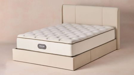 The Marriott Innerspring mattress from JW Marriott hotels in a cream bed frame in a room with a pale peach background