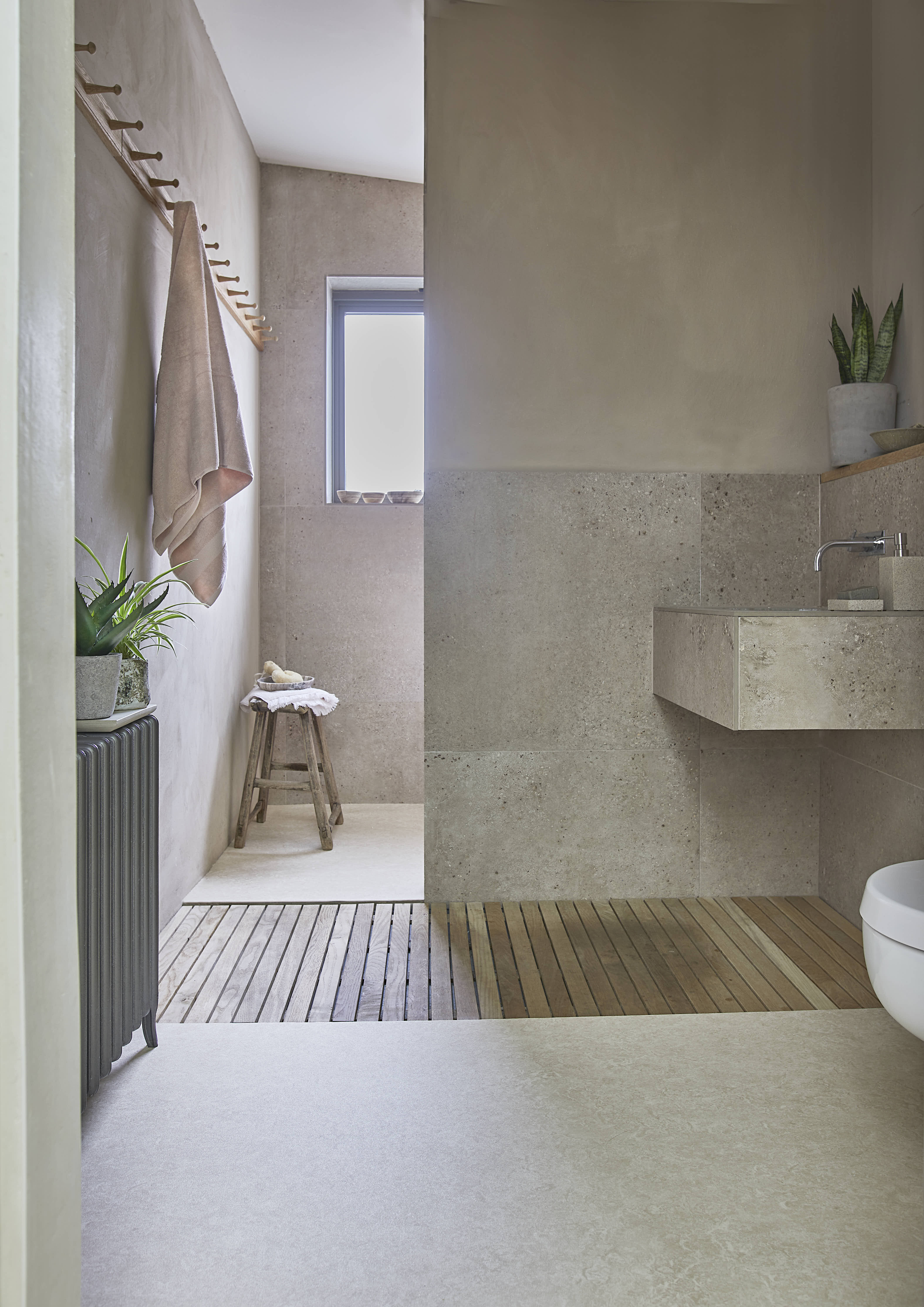 neutral bathroom with vinyl flooring, pared back style, wet room in background