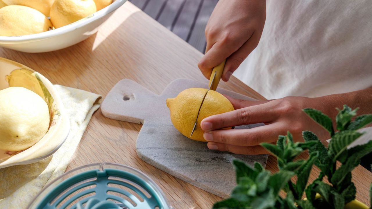 Woman chopping lemons on a marble chopping board