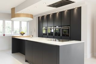 a handleless kitchen with a bank of ovens