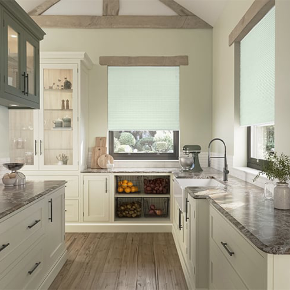 green honeycomb blinds in kitchen with cream cabinets and wooden floor