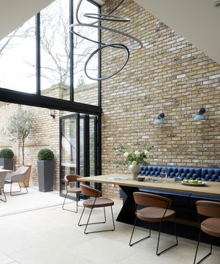 Open plan dining area with exposed brick wall in Georgian townhouse in London