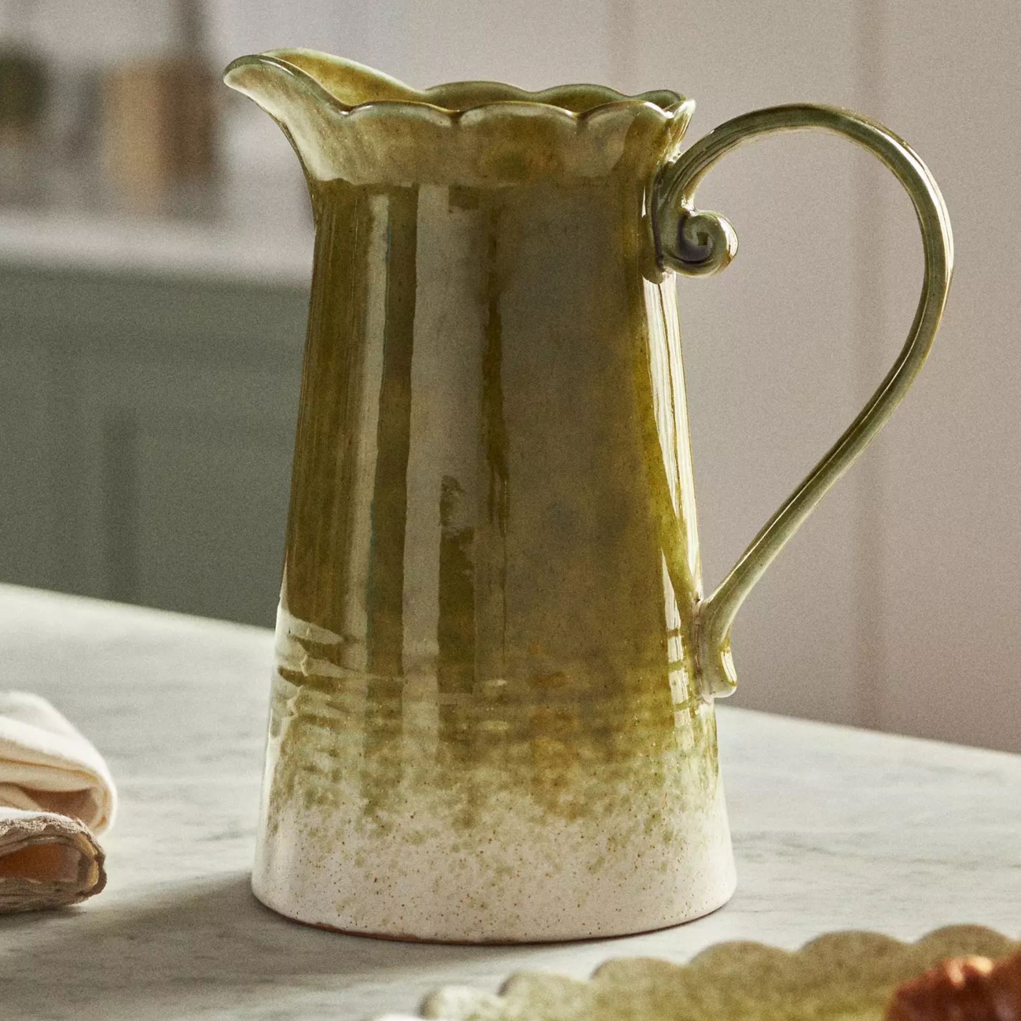 Olive green stone pitcher with a white speckled base