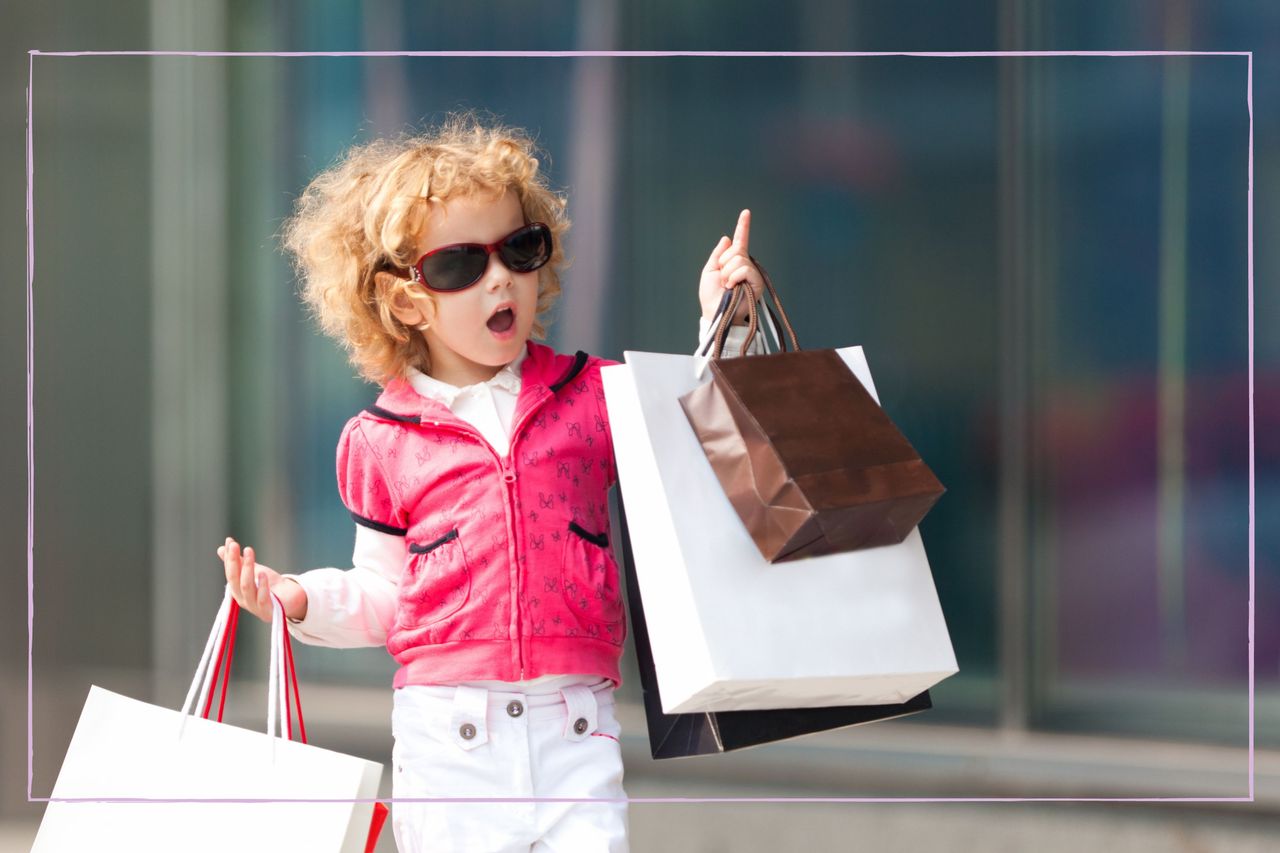 Baby girl carrying designer shopping bags