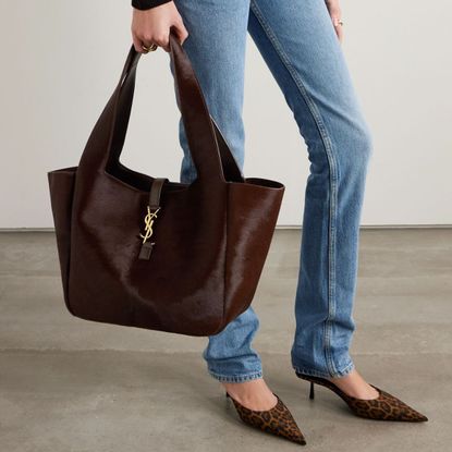 a model carrying a brown ponyhair bag from saint laurent