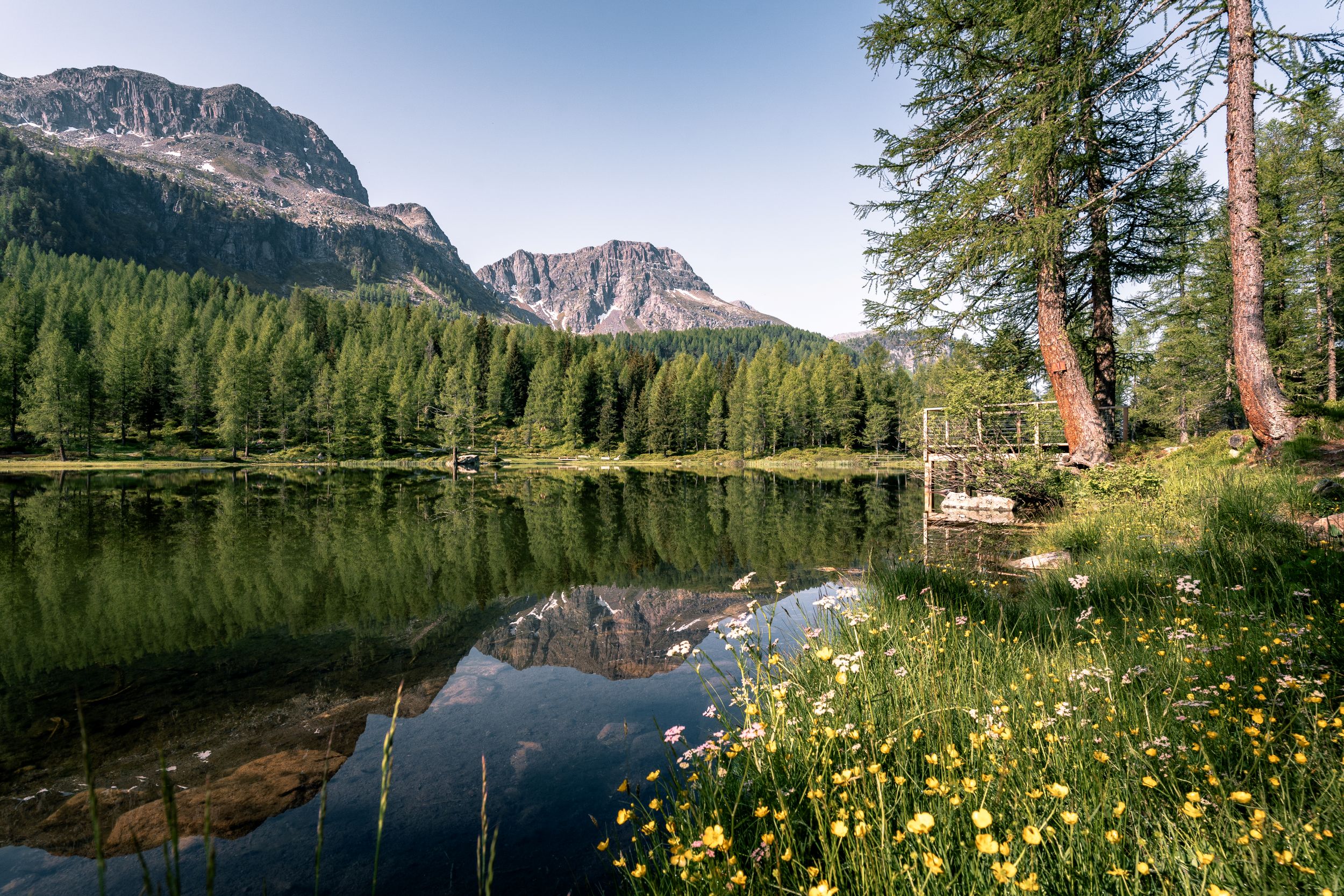 A photo of a lake with mountains in the background in the Val di Fassa region