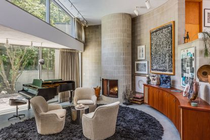 a living room with three chairs and a piano
