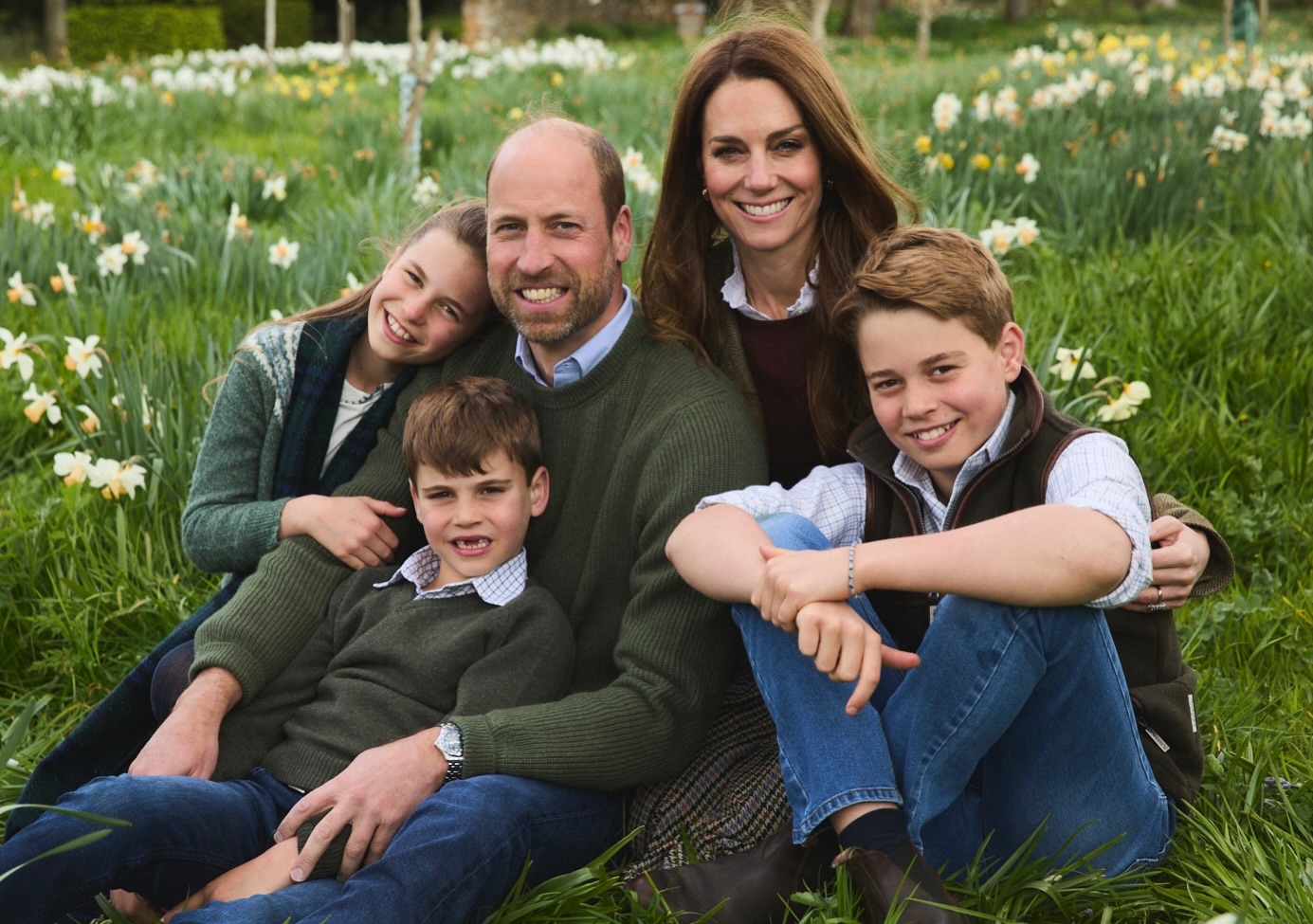 Prince William, Princess Kate, Princess Charlotte, Prince Louis and Prince George sitting in a field of flowers