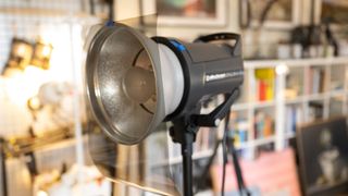 An Elinchrom D-Lite flash head with a sheet of polarizing filter material attached to the front of it