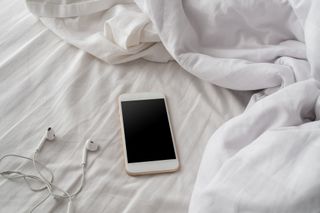 High Angle View Of Mobile Phone On Bed