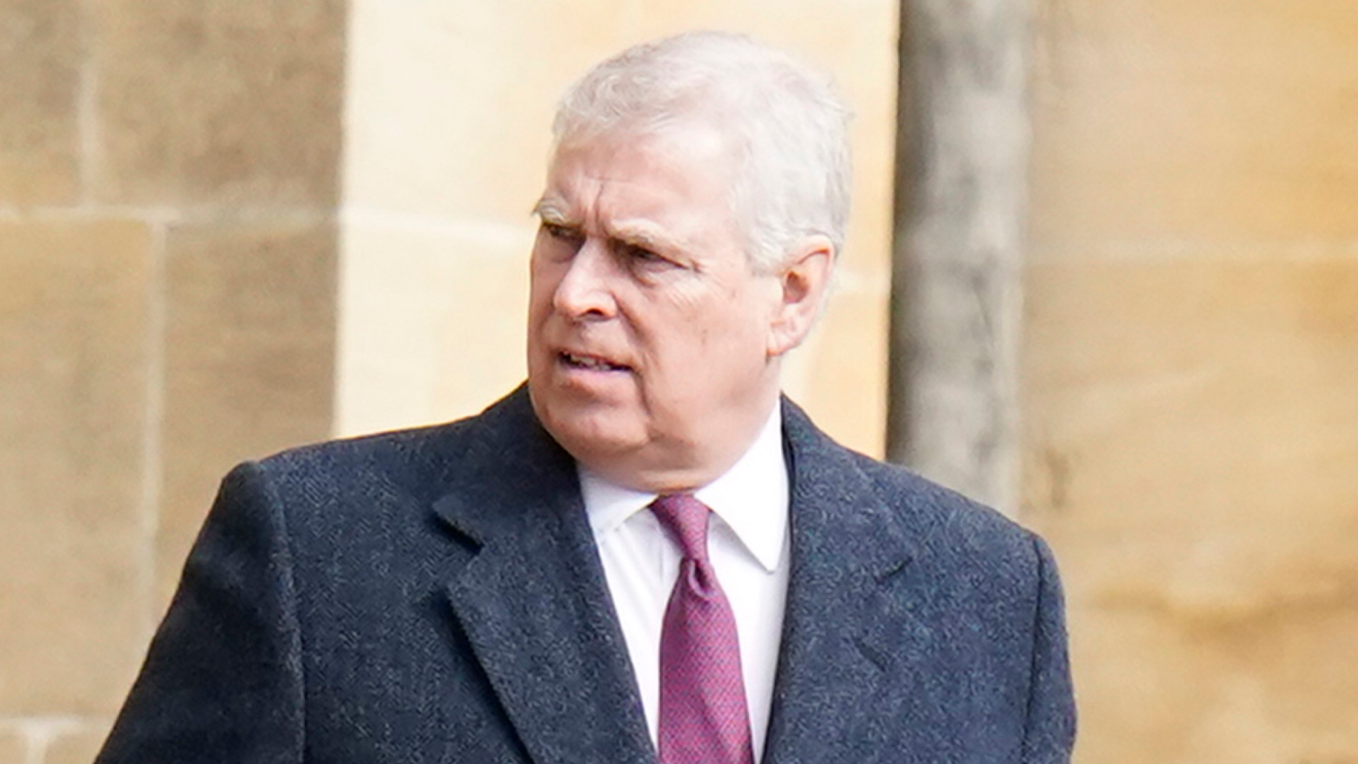 Ex-Prince Andrew looks shocked while wearing a dark gray overcoat with a white shirt and red and purple tie