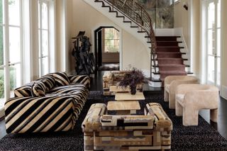 A symmetrical living room with a black and white stripe sofa and matching sculpture