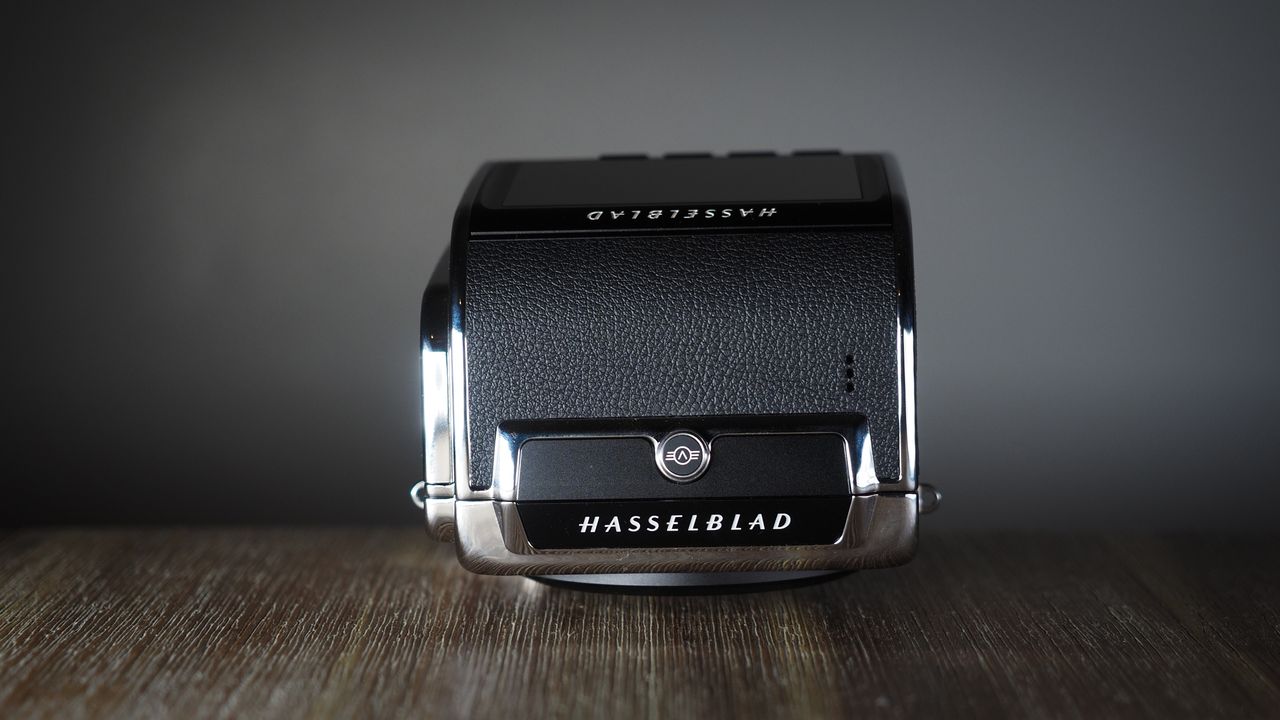 The Hasselblad 907X &amp; CFV 100C medium format camera with digital back, on a wooden table with artistic lighting