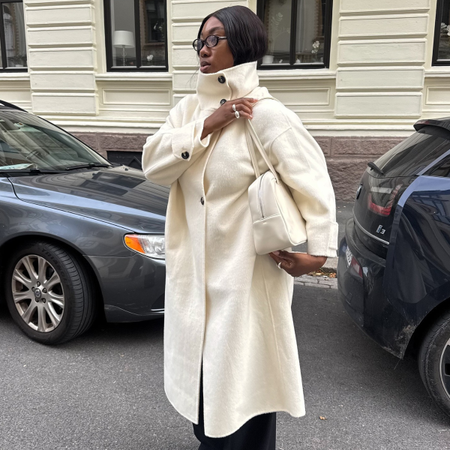 Fashion person Nnennae Chem wears a best wool coat. She wears a long white wool coat.