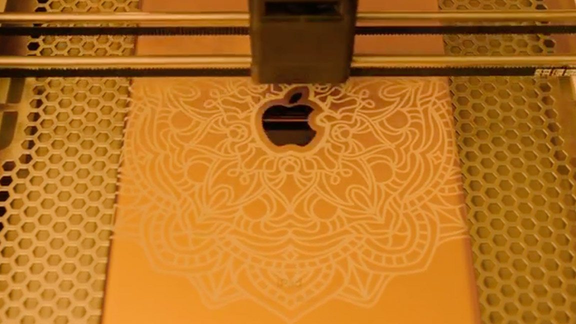 Glowforge Aura; a laser engraves a pattern onto a MacBook Air