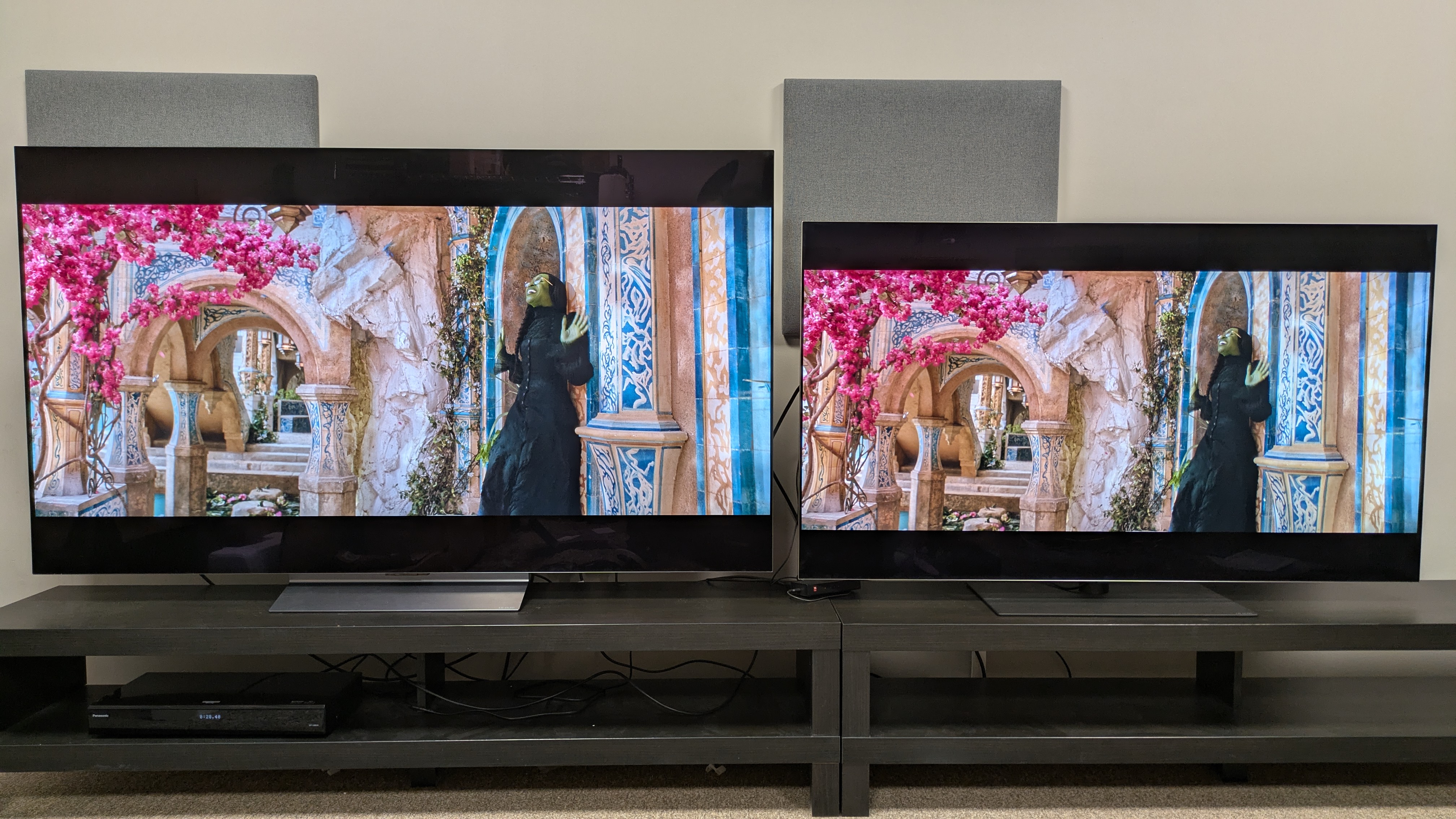 LG C6 (left) and LG G5 (right) with a scene from Wicked, with Elphaba standing under a tree. The G5 has more vibrant, striking colors, particularly of the pink flowers in the tree