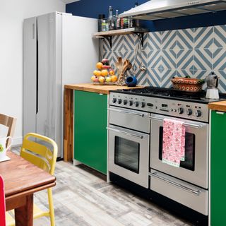 Kitchen with stainless steel ovens and green cabinetry