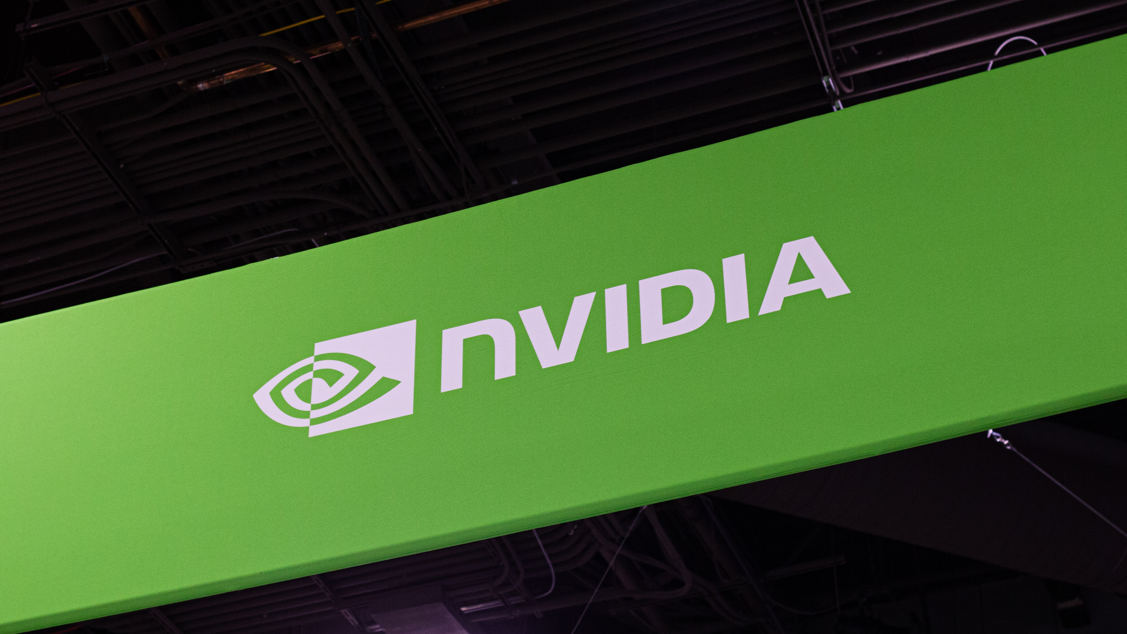The Nvidia logo on a banner within a conference center.