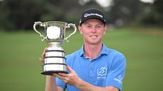 Ryggs Johnston holds up the Australian Open trophy after winning in 2024